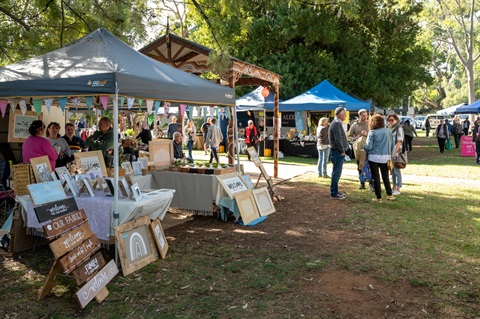 Market stalls and patrons in garden