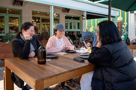 Ladies and baby seated at table in outdoor dining area